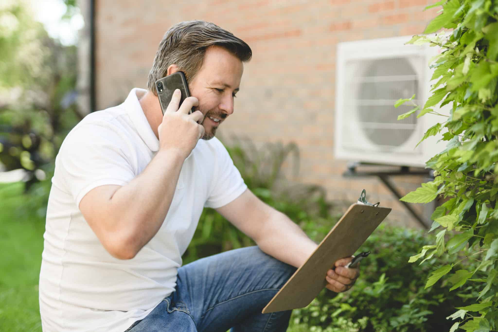 An empowered homeowner on the phone reviews an HVAC maintenance checklist.